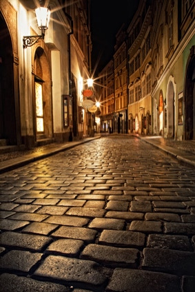 Bild zeigt eine beleichtete Gasse in der Nacht